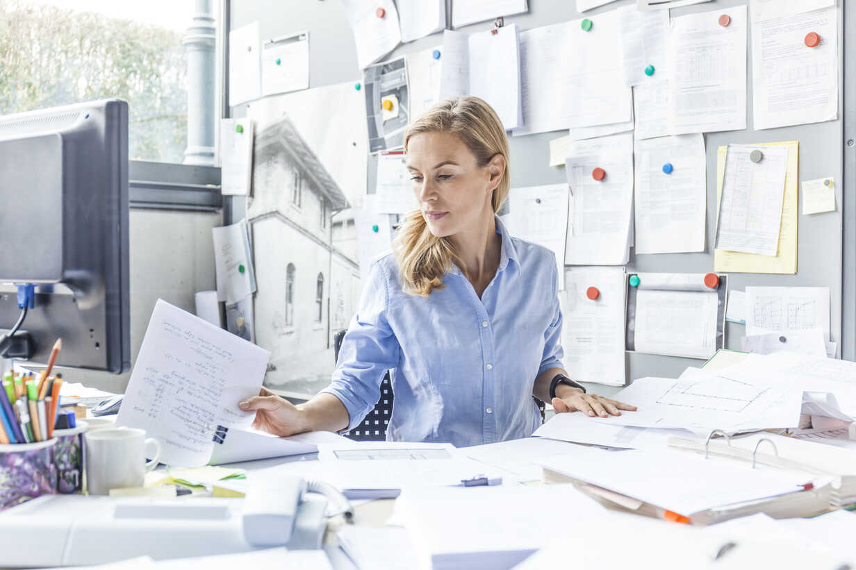 Woman sitting at desk in office doing paperwork